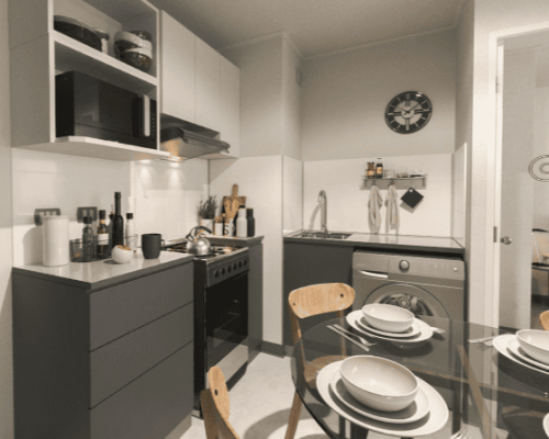 Cocina americana funcional equipada con muebles a medida y encimera, optimizada para el espacio del modelo Mariposa.