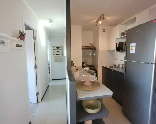 Pasillo interior con piso cerámico que conecta el área social con los dormitorios y el baño del departamento
