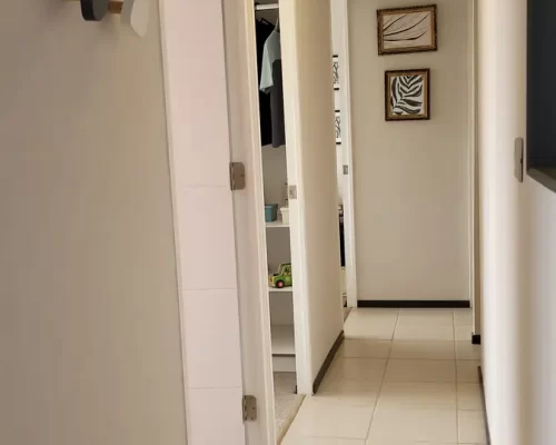 Pasillo interior iluminado con piso cerámico que conecta los tres dormitorios y el baño de forma eficiente