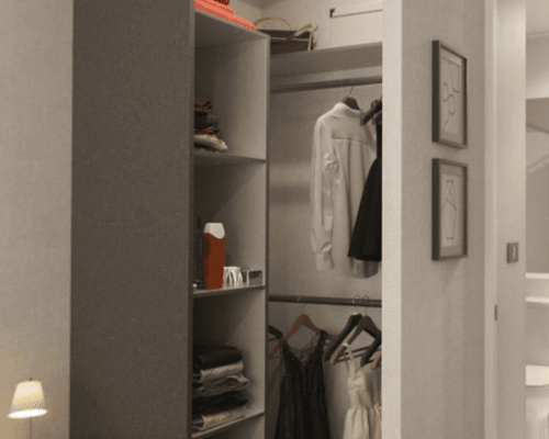 Detalle del interior de un amplio walk-in closet con estanterías blancas dentro de la habitación principal.