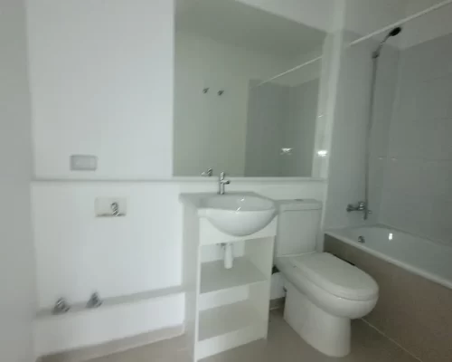 Baño completo con tina, vanitorio moderno y nicho con conexiones para instalación de lavadora